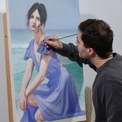 Artist painting a woman in a blue dress on an easel