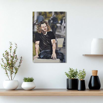 'In A Moment Of Silence' oil painting of a man hanging on a wall above a shelf with decorative plants.