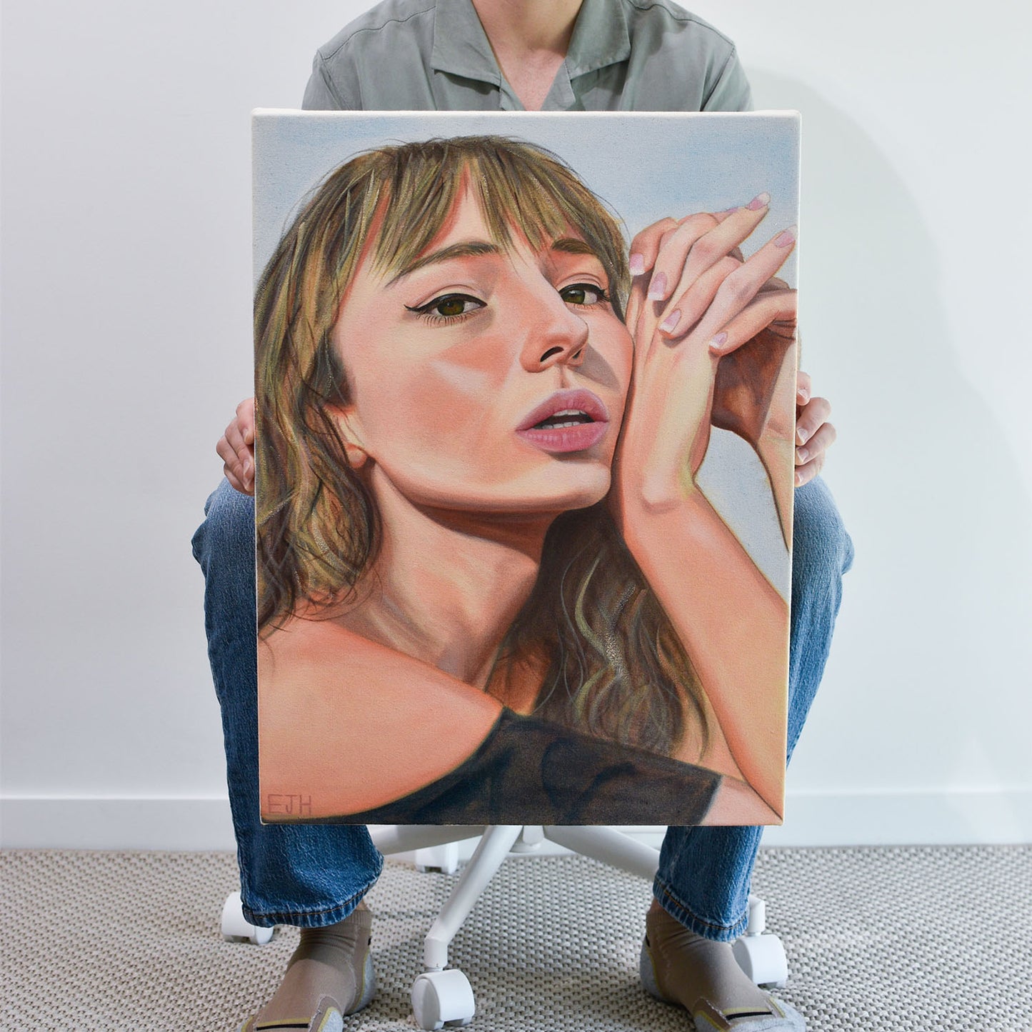 Artist holding 'Sunbleached Girl' oil painting of a woman.