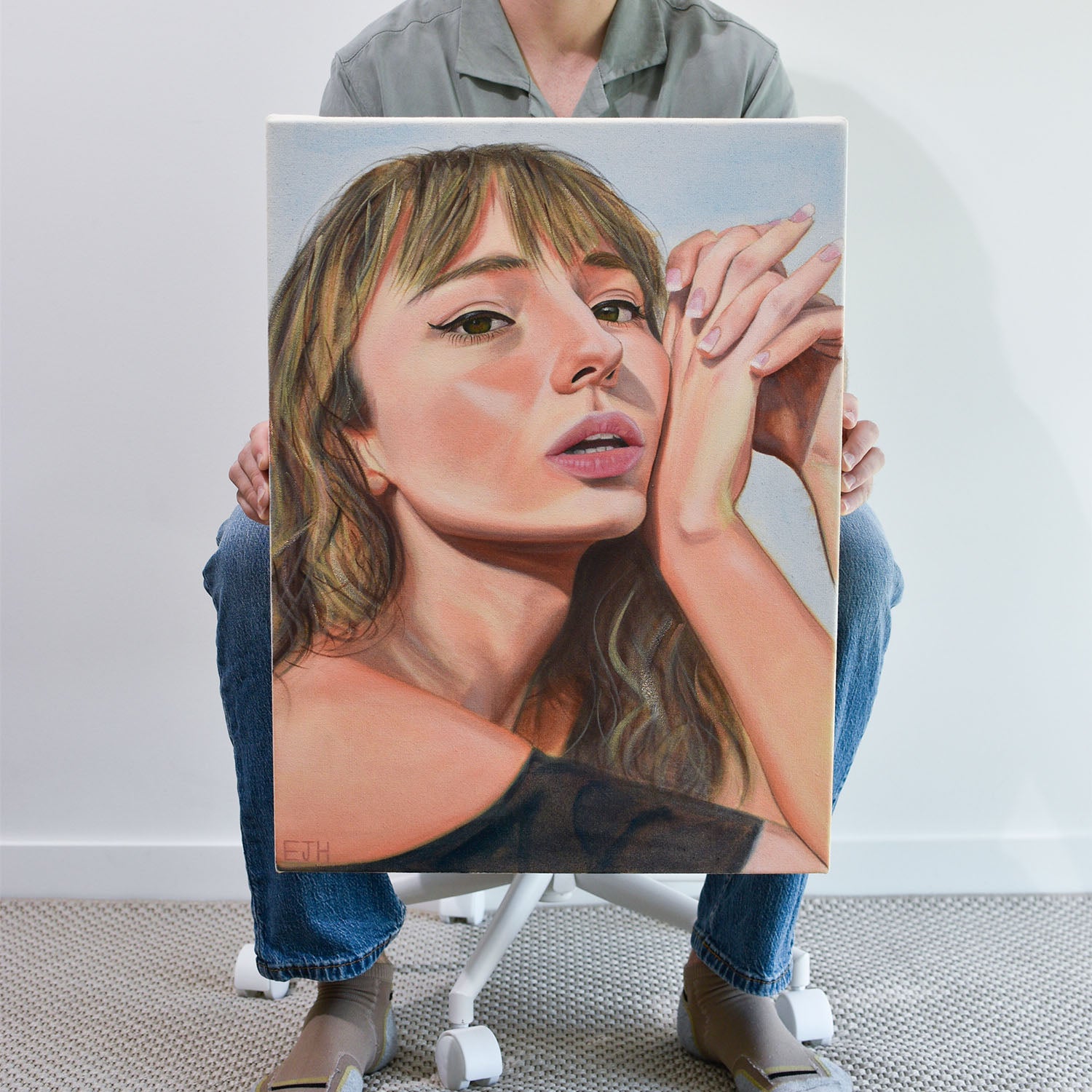 Artist holding 'Sunbleached Girl' oil painting of a woman.