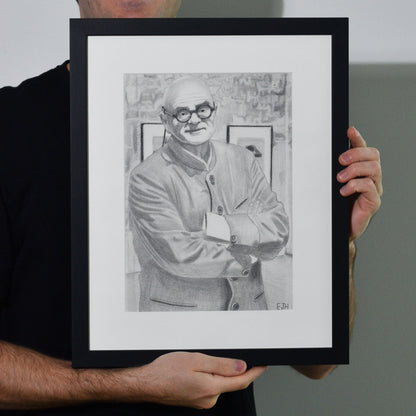 Artist holding 'The Art Dealer', framed drawing portrait.