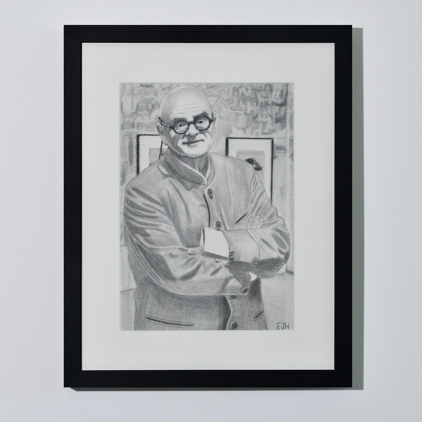'The Art Dealer' framed portrait drawing of a man in jacket hanging on a neutral wall in the artist's studio.