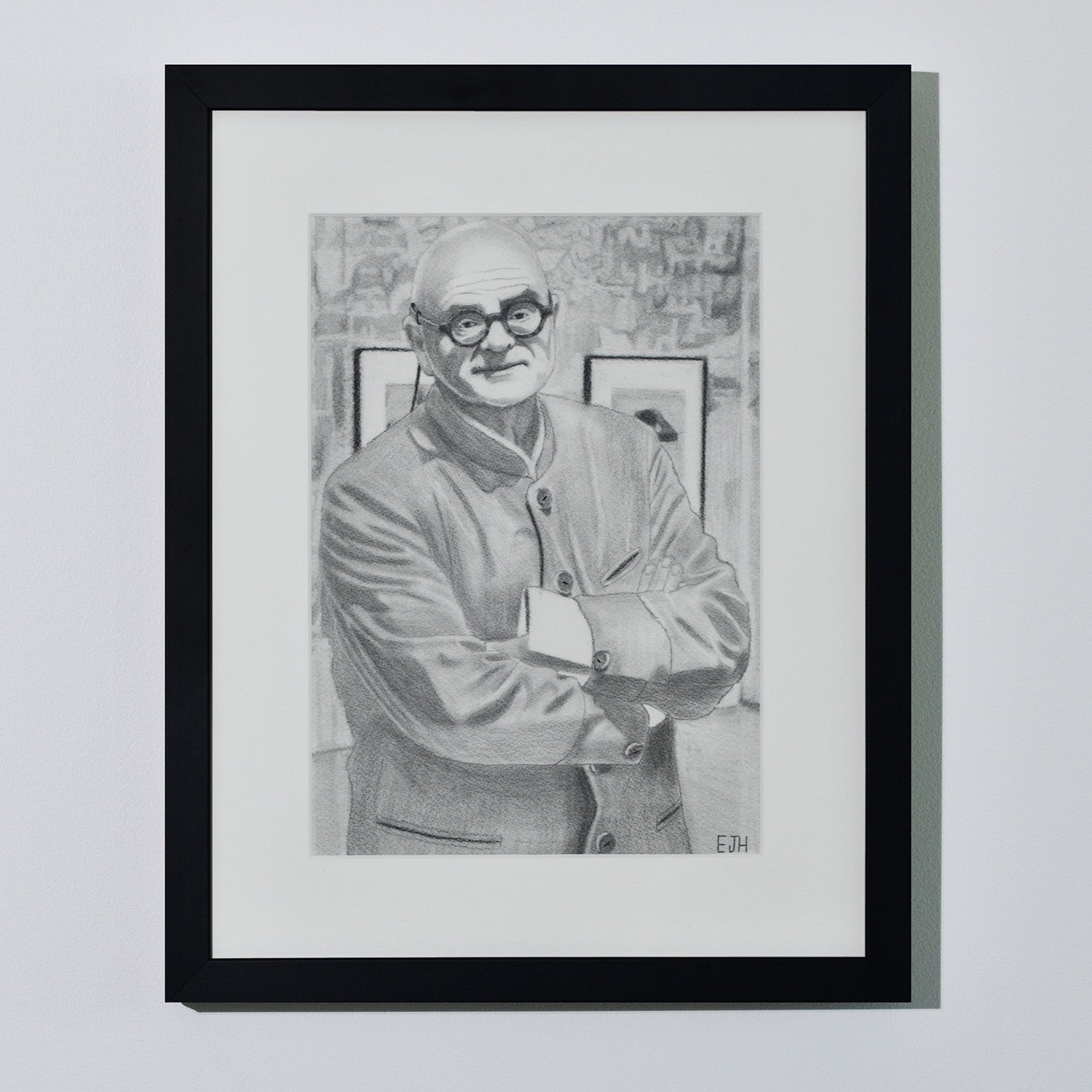 'The Art Dealer' framed portrait drawing of a man in jacket hanging on a neutral wall in the artist's studio.