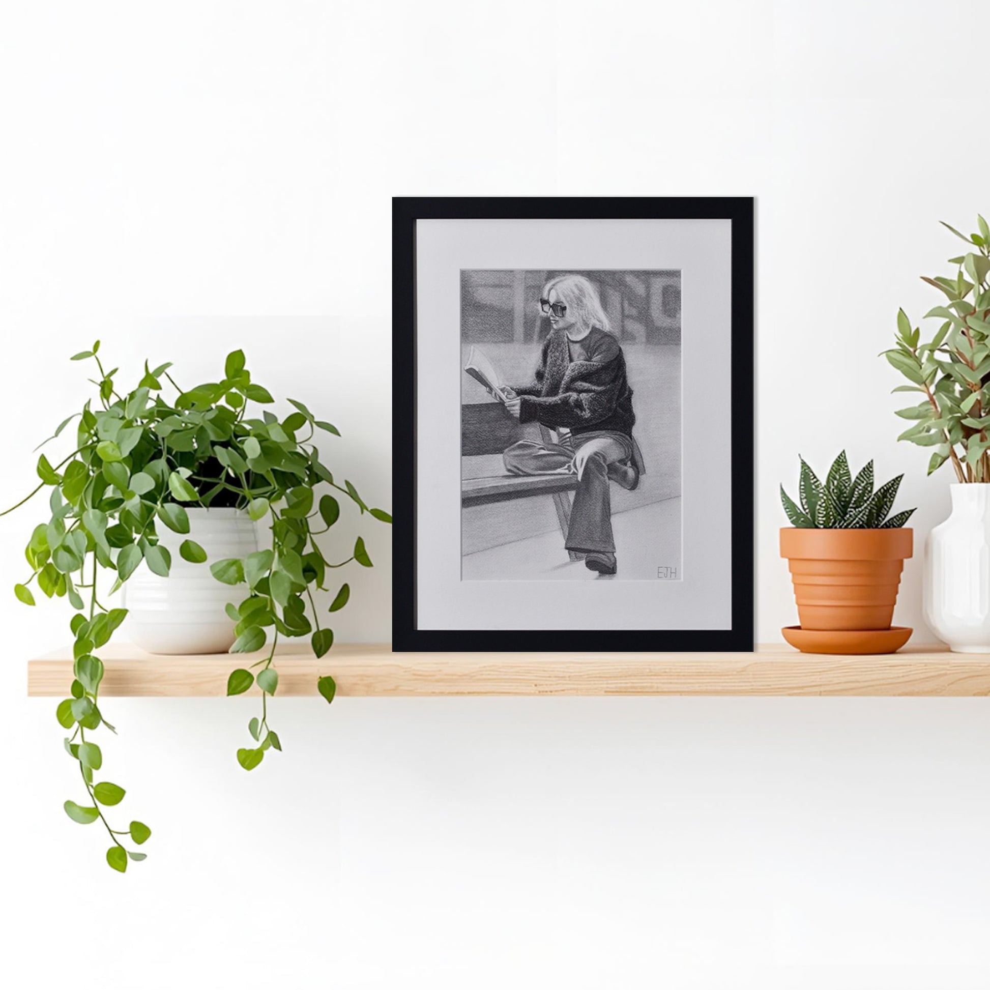 'The Pages We Choose To Fill', drawing of a woman reading a book hanging on a shelf with plants.