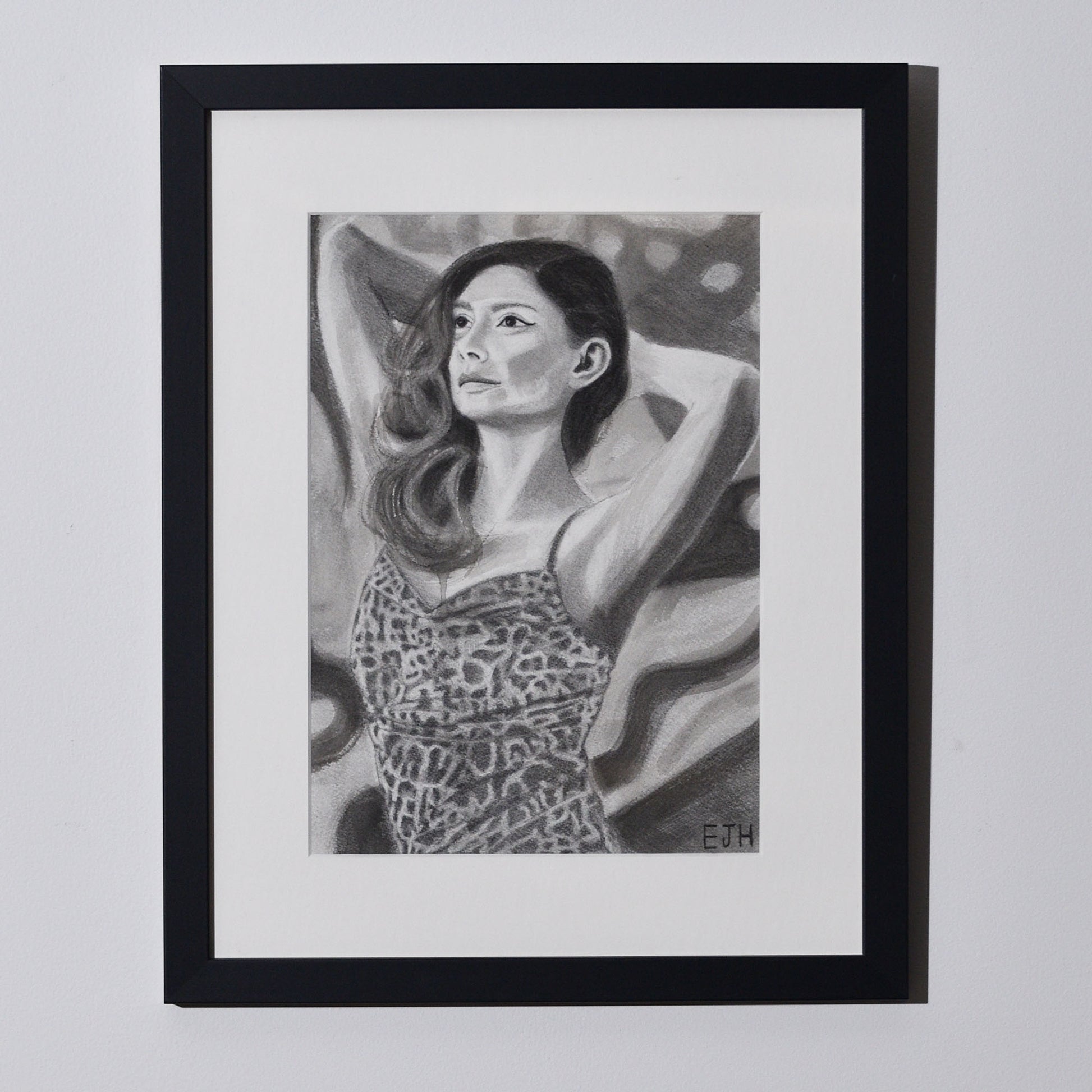 'The Spaces Between Patterns' framed portrait drawing of a woman in leopard print dress hanging on a neutral wall in the artist's studio.