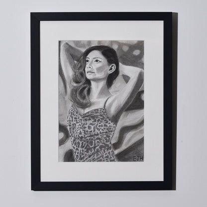 'The Spaces Between Patterns' framed portrait drawing of a woman in leopard print dress hanging on a neutral wall in the artist's studio.