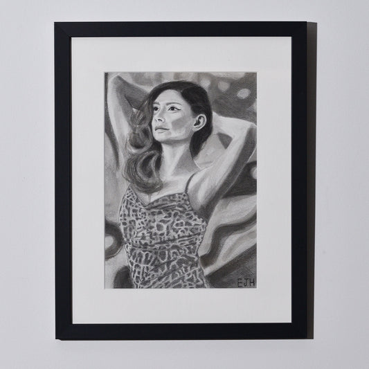'The Spaces Between Patterns' framed portrait drawing of a woman in leopard print dress hanging on a neutral wall in the artist's studio.