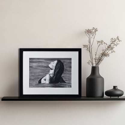 'The Sunbather' framed portrait drawing of a woman in water hanging on a shelf with decorative vases.